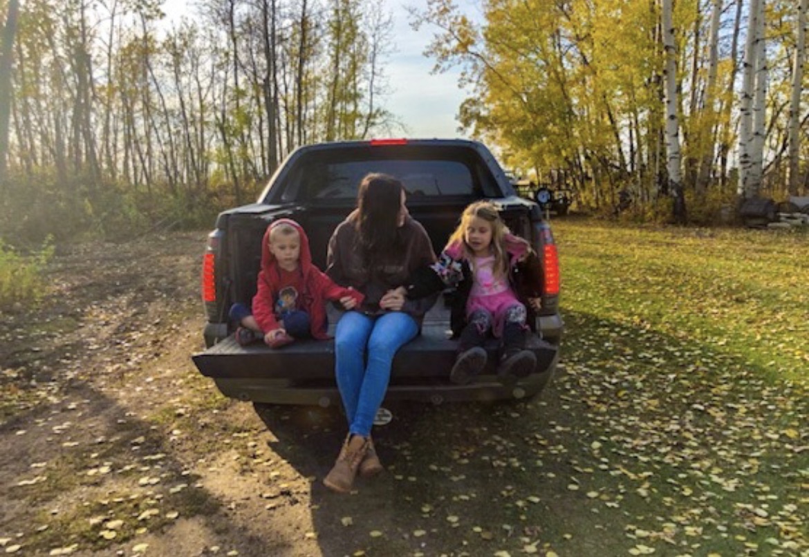 Sitting on the tailgate with the kids in autumn poplars