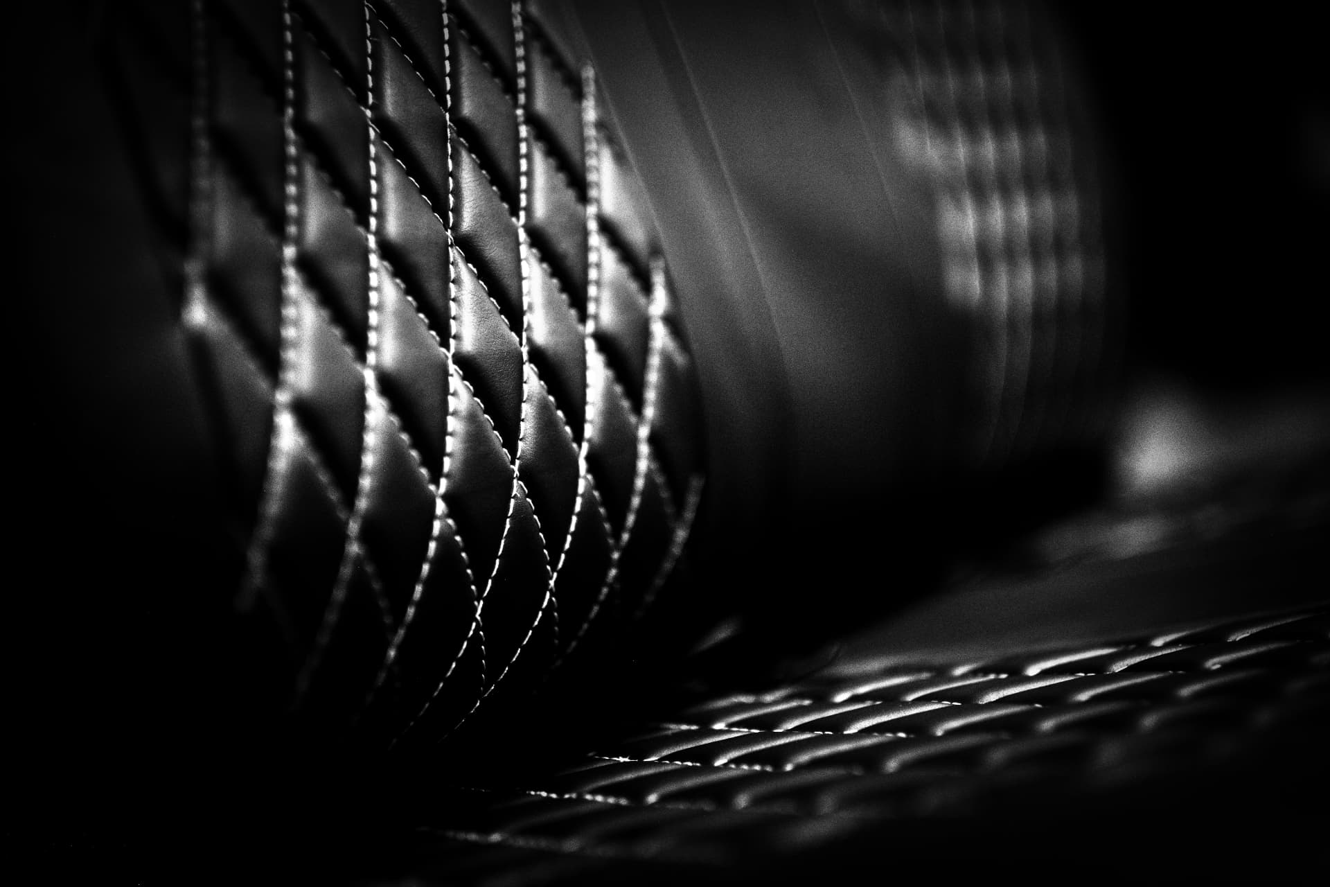 Diamond-stitched leather rolling away into shadow