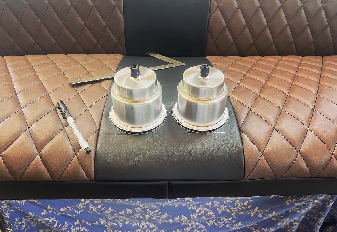 Diamond-stitched bench seat with fitted cup holders being laid out