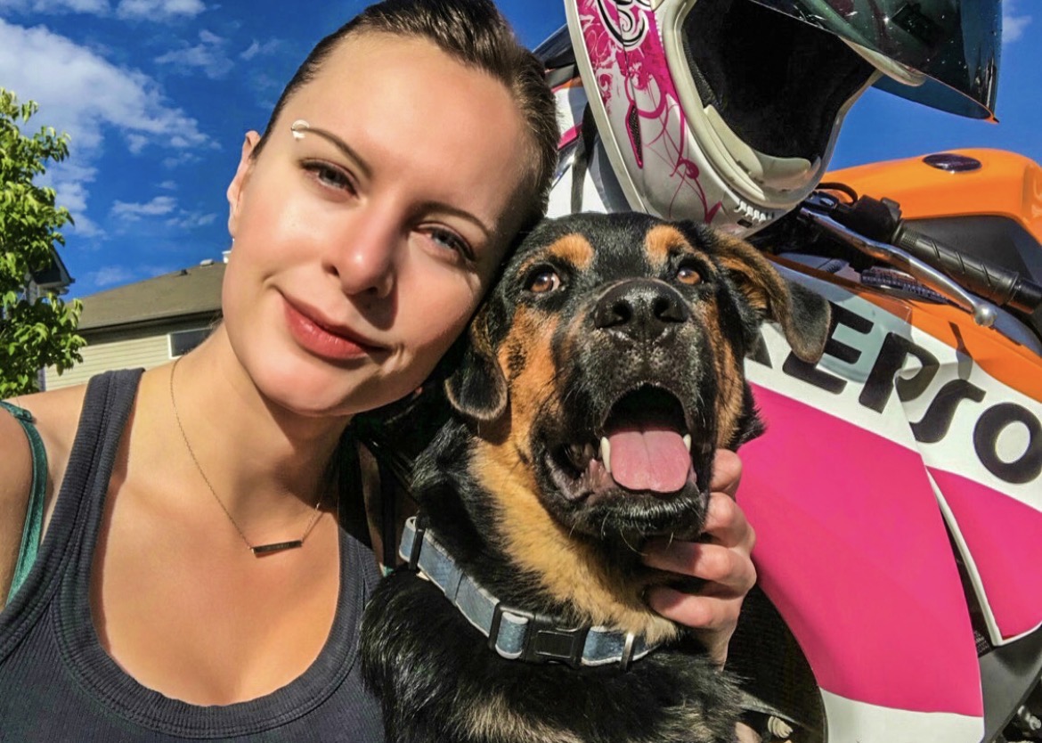 With a dog beside the motorcycle on a clear summer day