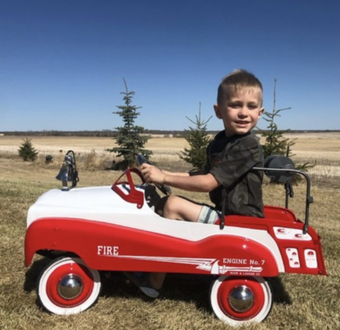 A restored pedal fire engine out in the prairie sun