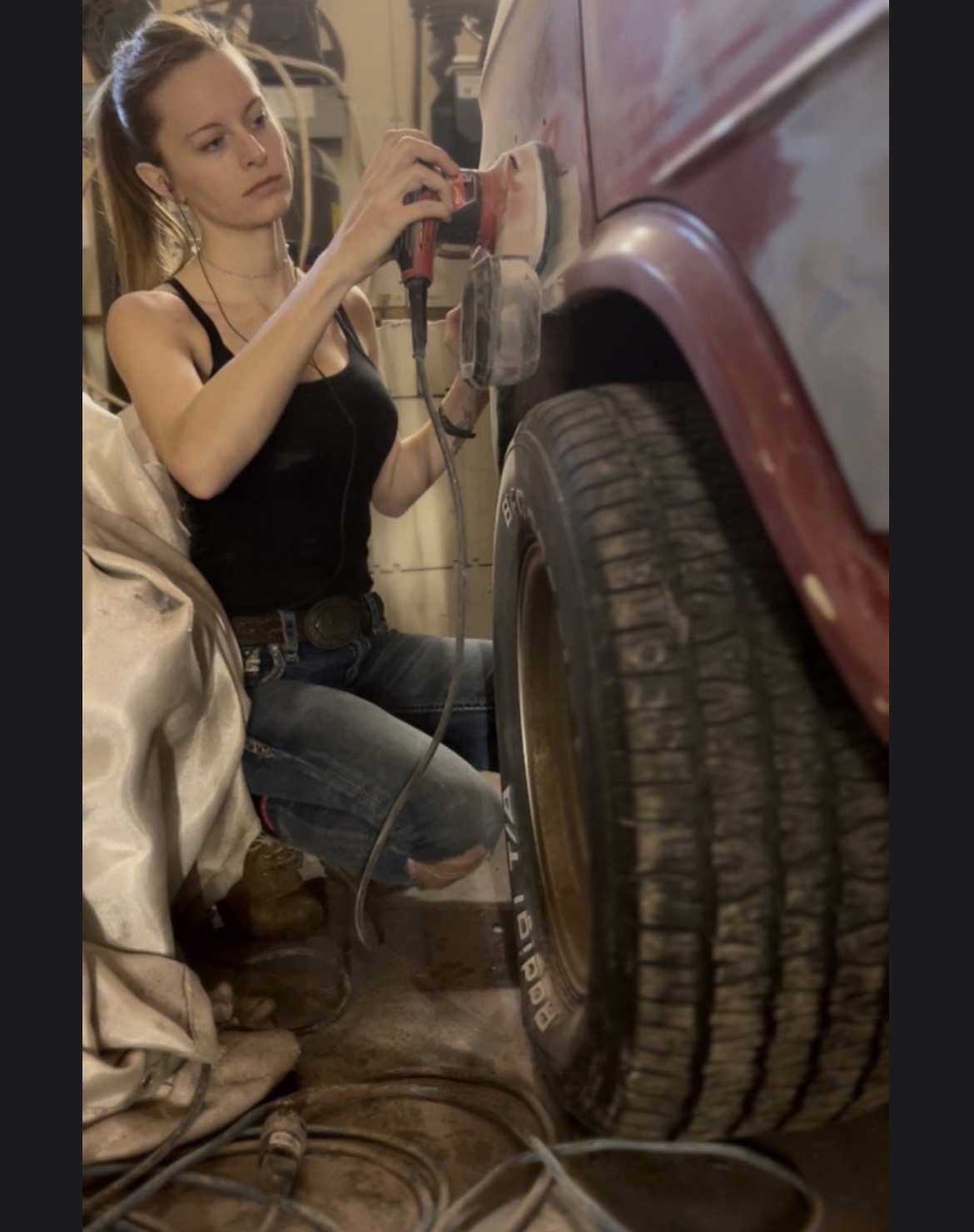 Sanding a fender back to bare metal in the shop