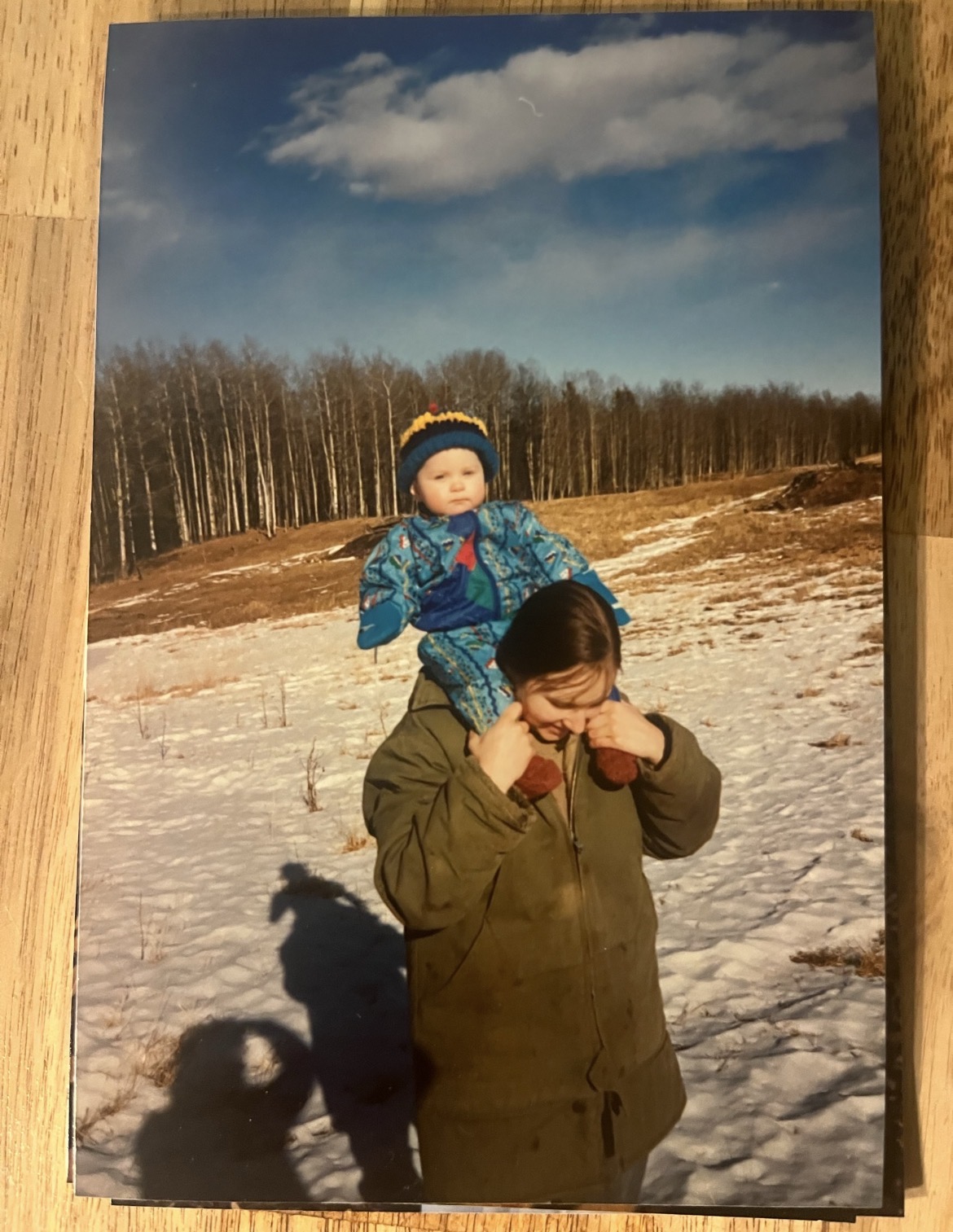 A childhood photo carried up on shoulders across a snowy field
