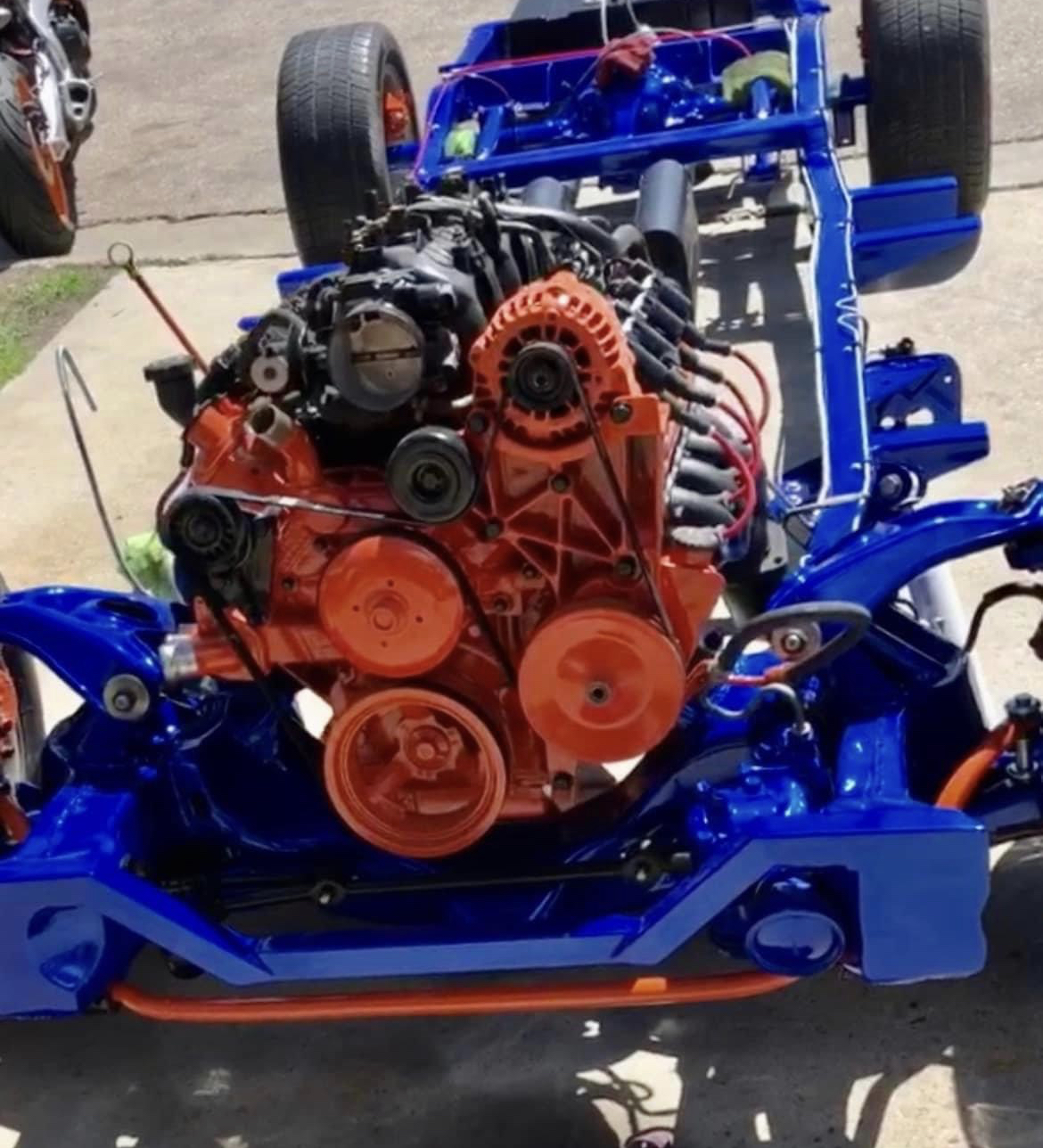 A rolling chassis in blue with a rebuilt engine set in place