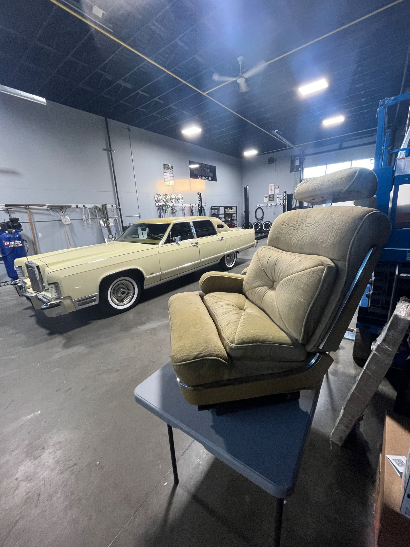 A reupholstered seat beside a classic sedan