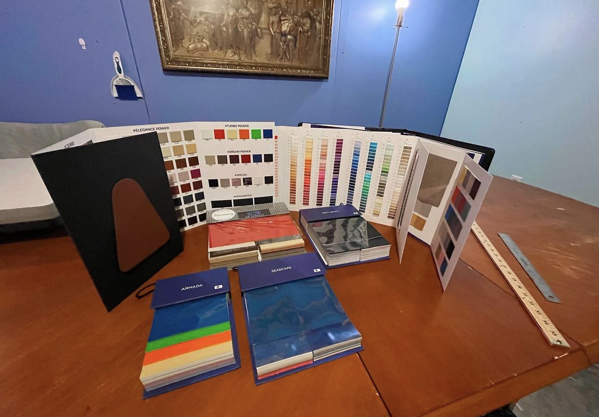 Leather, vinyl and thread sample books on the work table